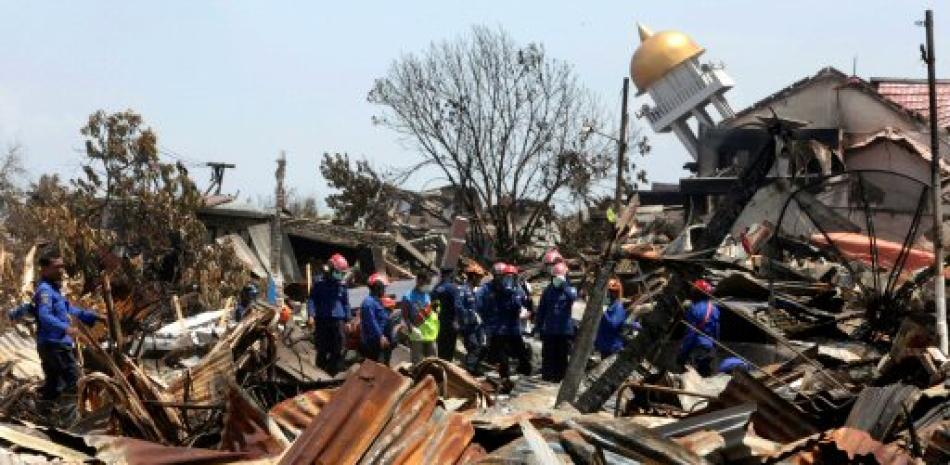 Bomberos trabajan en la búsqueda de víctimas tras el terremoto y posterior tsunami en las calles de Palu, Indonesia. Foto de AP./