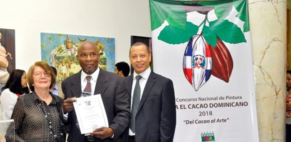 Pancracio Almonte, tercer lugar recibe el certificado de las manos de Marianne de Tolentino y el director ejecutivo de Conacado Isidro de la Rosa.