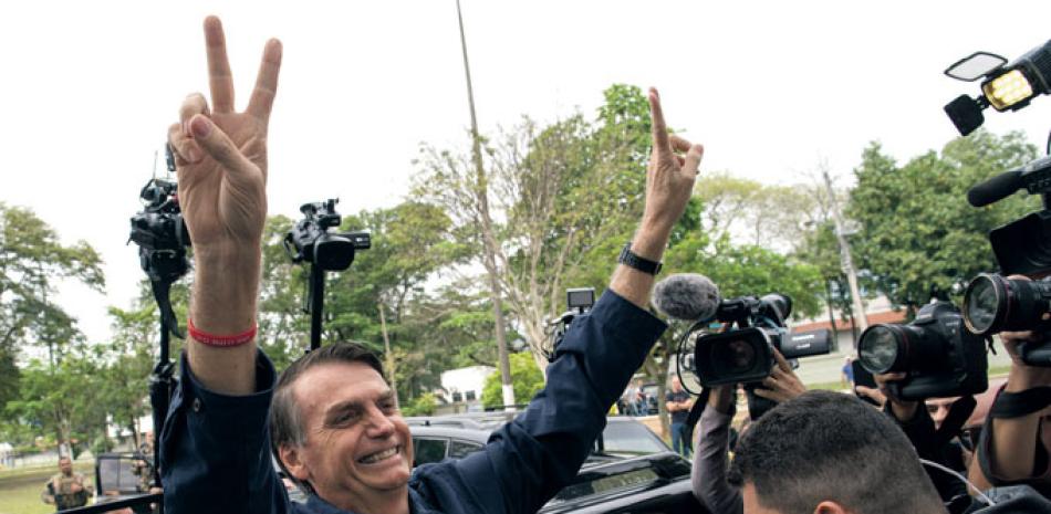 Reconocidos. El candidato Jair Bolsonaro luego de votar ayer domingo.