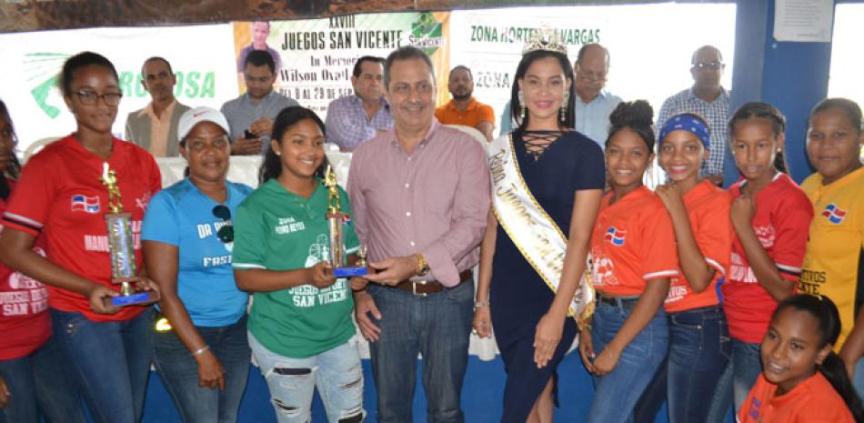El licenciado Luis Yanguela premia a las atletas del softbol femenino de la zona Manuel López y la jugadora Massiel Fernández como la más valiosa.