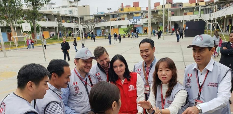 El juez titular del TSE, Ramón Arístides Madera Arias (derecha), junto a un grupo de observadores internacionales durante las elecciones del domingo en Perú.