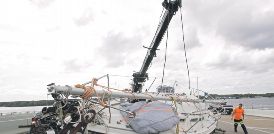 Preparativos. Miembros de una tripulación trabajan para levantar un barco de vela que se ha desprendido de su remolque en una parte bloqueada de la autopista US 98, mientras el área se prepara para el impacto del huracán Michael en Panama City, Florida.