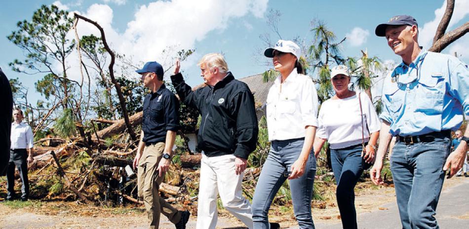 Recorrido. El presidente Donald Trump junto a funcionarios de Florida y la primera dama Melania Trump durante el recorrido por un vecindario afectado por el huracán Michael.