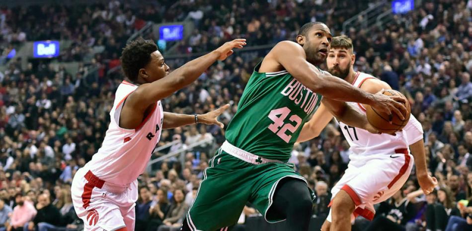 Al Horford, de los Celtics, recibe una falta personal de Kyle Lowry, de Toronto, en su gestión ofensivo durante el partido de anoche en la NBA.