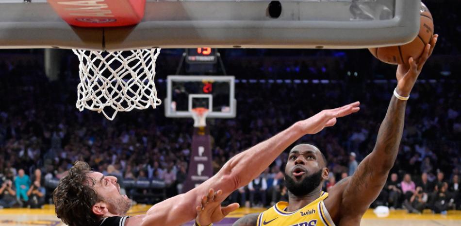 Pau Gasol, de los Spurs, trata de bloquear un intento al canasto de LeBron James, de los Lakers, en el partido de lunes por la noche.