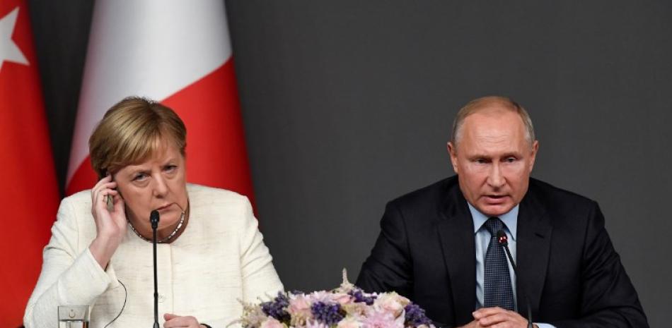 El presidente ruso Vladimir Putin y la canciller alemana, Angela Merkel, asisten a una conferencia como parte de la cumbre convocada para intentar encontrar una solución política duradera a la guerra civil en Siria.