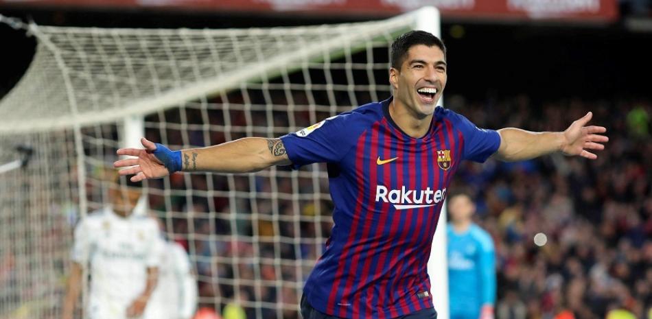 El delantero uruguayo del FC Barcelona, Luis Suárez, se lleva el balón tras conseguir un "hat trick" en el partido de liga disputado en el Camp Nou.