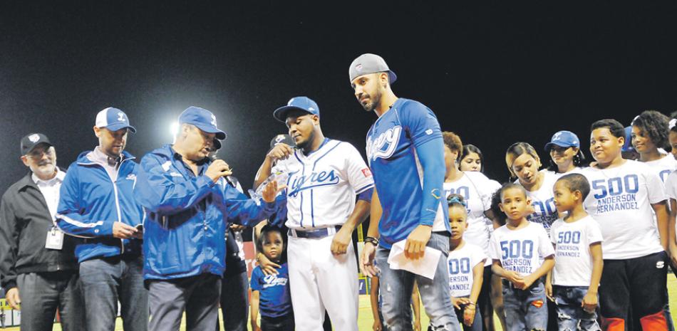 El presidente del Licey, Jaime Alsina entrega un placa a Anderson Hernández tras conectar su imparable 500. Figuran Miguel Guerra y el presidente de la Liga de Béisbol, Vitelio Mejía.