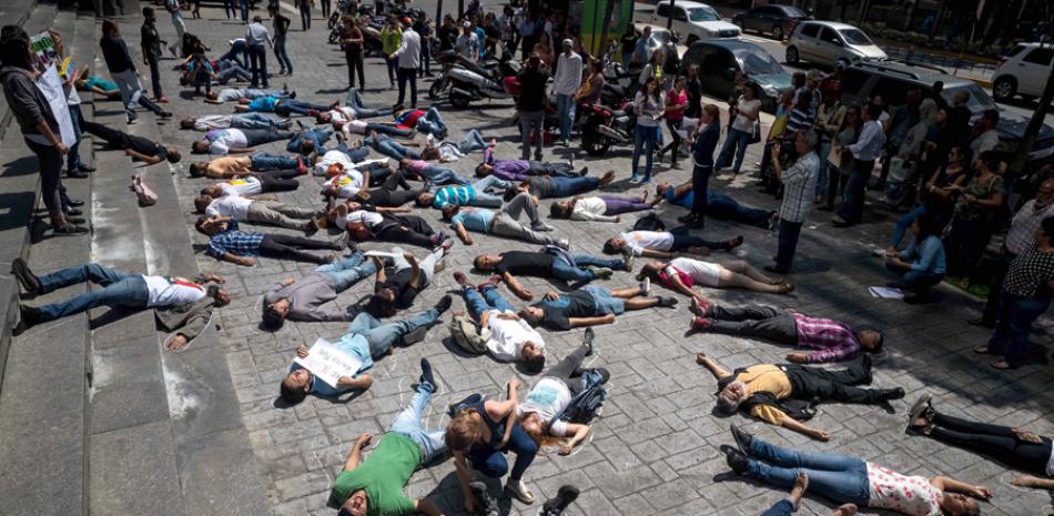 Simulacro. Los opositores se acostaron en el asfalto simulando a las personas que fallecieron en las protestas antigubernamentales de 2014 y 2017.