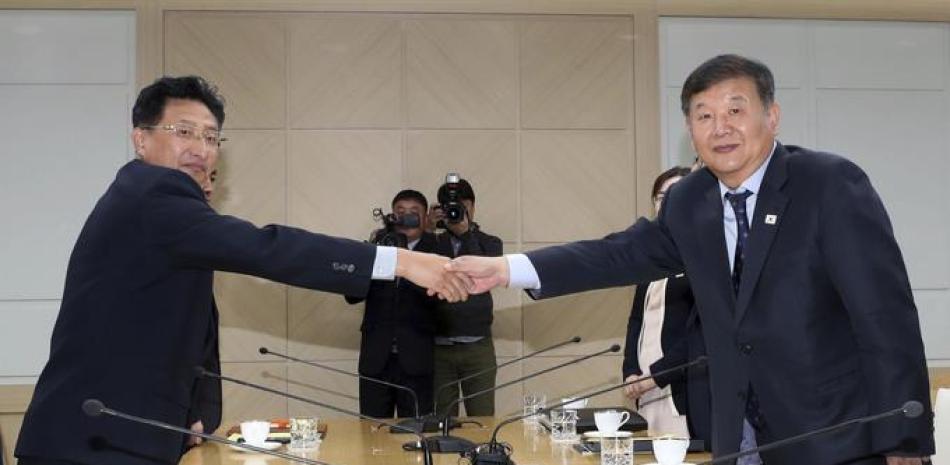 El viceministro de Cultura y Deporte surcoreano, Roh Tae-kang (d), estrecha la mano a su homólogo norcoreano, Won Kil-u, durante la reunión que celebraron en el complejo industrial intercoreano de Kaesong.