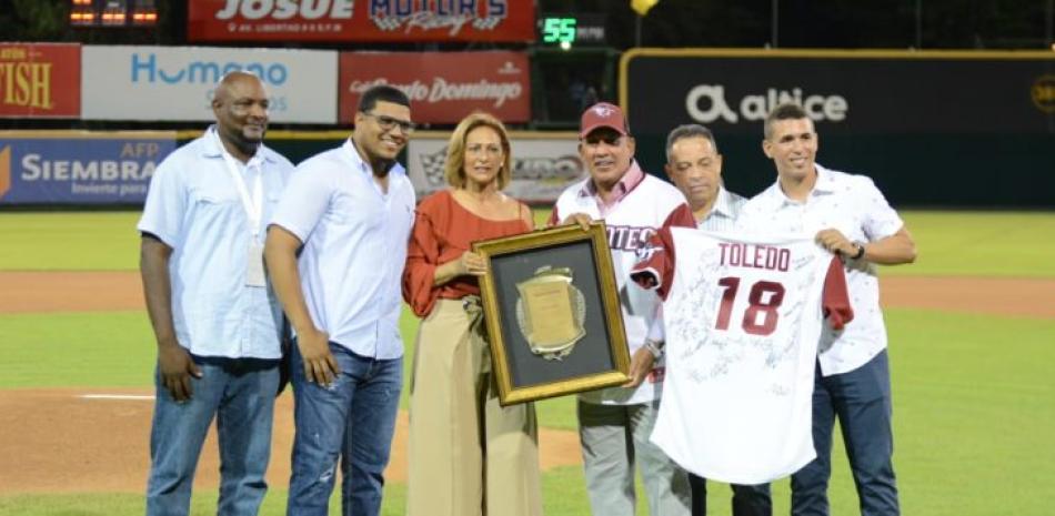 Los señores Yisell Infante, y  Rafael Almánzar, ejecutivos de los Gigantes del Cibao, entregan un reconocimiento a Eddy Toledo, ex gerente del equipo.