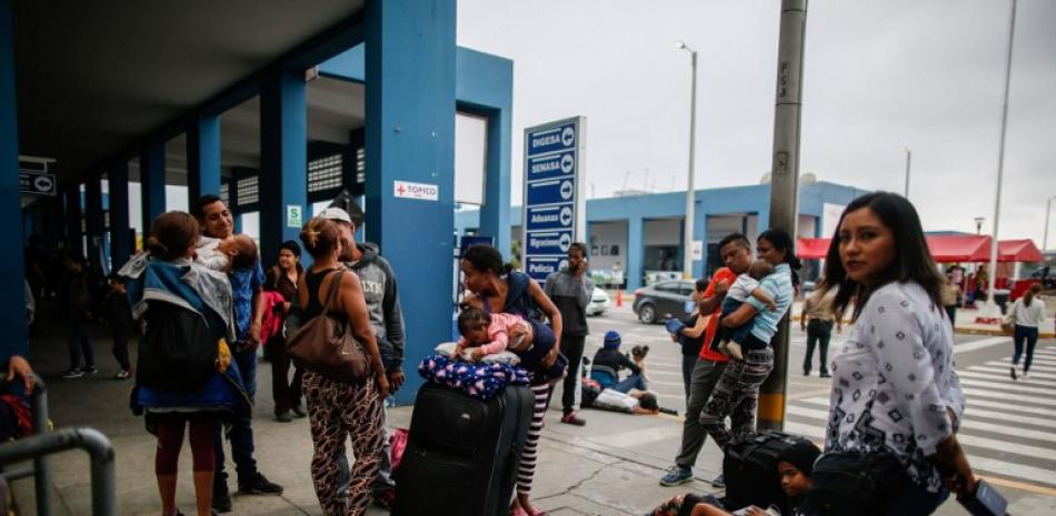 Migrantes venezolanos a la espera para entrar a Perú, huyendo de la crisis que afecta su nación.