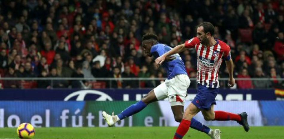 Iñaki Williams avanza con el balón tras el asedio de Diego Godin durante el aprtido que el Atlético de Madrid se impuso este sábado al Bilbao