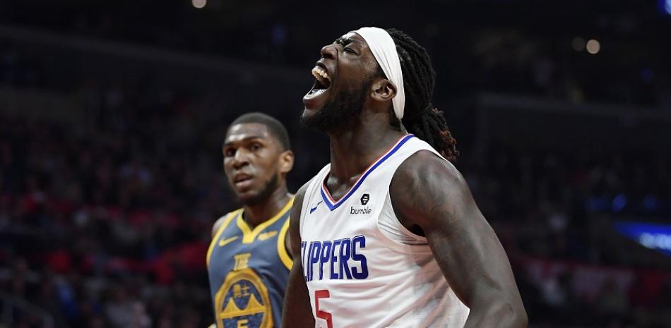 El delantero de los Clippers, Montrezl Harrell, celebra despues de anotar dos puntos contra Golden State ante la mirada de Kevon Looney.