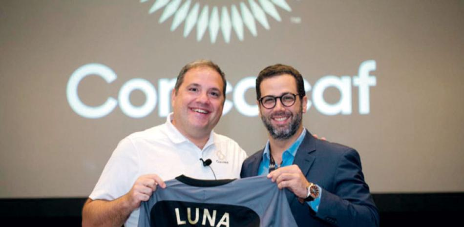 Víctor Montagriani, presidente de la Concacaf, entrega una camiseta con el apellido de Luna, durante un aparte de la reunión del organismo regional.