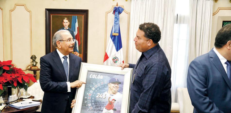El presidente Danilo Medina recibe un cuadro del veterano Bartolo Colón, en el cual están plasmadas las victorias alcanzadas con cada uno de los equipos con los que ha militado en las Mayores.