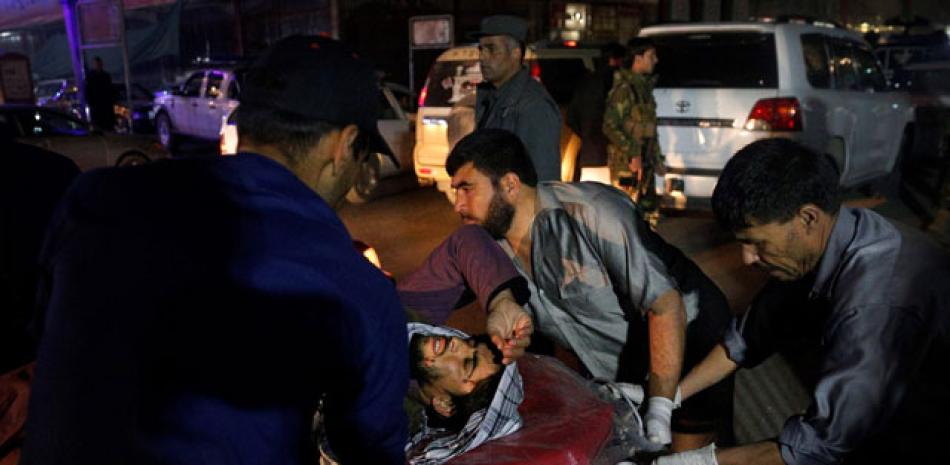 Rescate. Miembros de los servicios de emergencia transportan en camilla a un herido tras un ataque suicida ayer en Kabul.