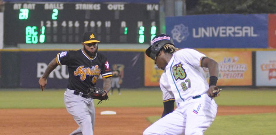 Gabriel Guerrero, de las Estrellas Orientales, regresa a salvo a la tercera base, mientras Ronny Rodríguez, de las Águilas, trata de ponerlo out.