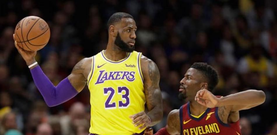 LeBron James, de los Lakers, sostiene el balón ante la defensa de David Nwaba, de los Cavaliers, en acción del partido del miércoles en el baloncesto de la NBA.
