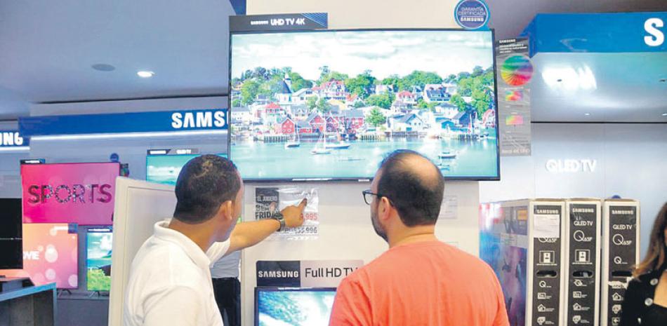 Un vendedor de Distribuidora Corripio muestra a un potencial comprador los descuentos realizados a un televisor por motivo del Viernes Negro.