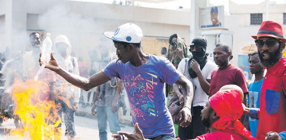 Protesta. Manifestantes incendian gomas durante una violenta protesta ayer en Puerto Príncipe. Miles se enfrentaron a los policías.