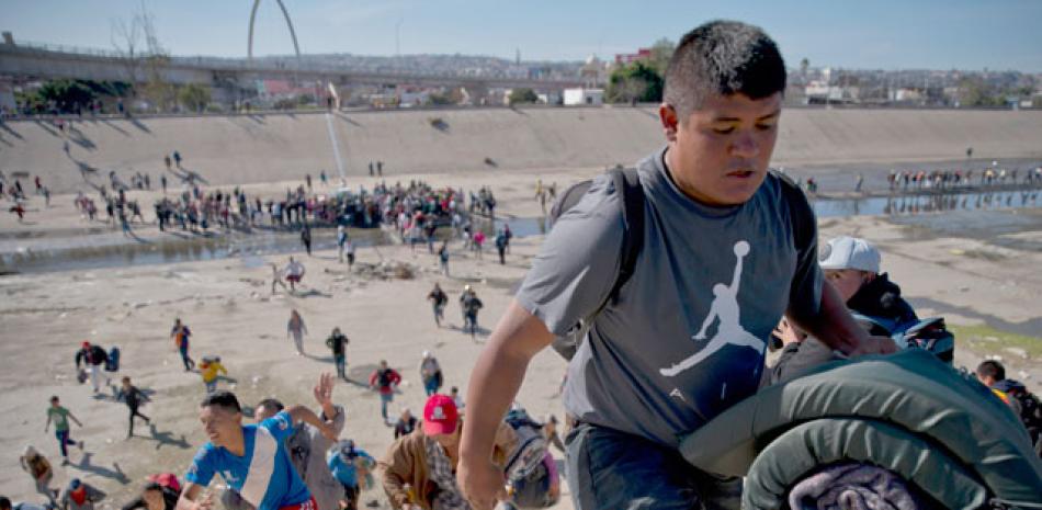 Asalto. Grupos de personas tratan de cruzar ayer la garita El Chaparral, de la ciudad de Tijuana, en el estado de Baja California.