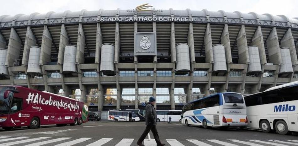 Un individuo camina frente al estadio Santiago Bernabeau, sorpresivo escenario de la final de la Copa Libertadores entre los archirrivales clubes argentinos Boca Juniors y River Plate.