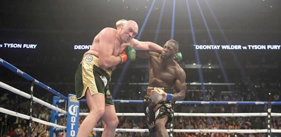 Deontay Wilder, a la derecha, conecta un golpe a Tyson Fury durante un combate por el título de los pesados del Consejo Mundial de Boxeo.