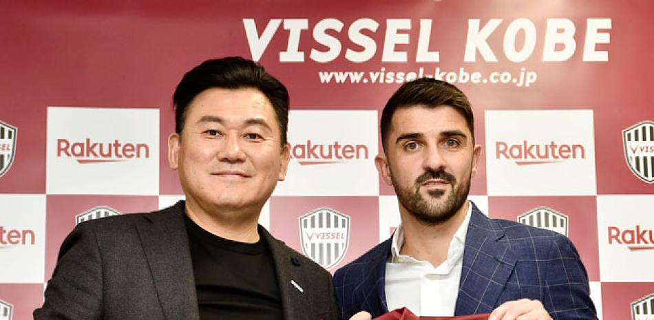 David Villa sostiene el uniforme del Vissell Kobe junto al dueño del equipo Hiroshi Mikitani en una conferencia de prensa.