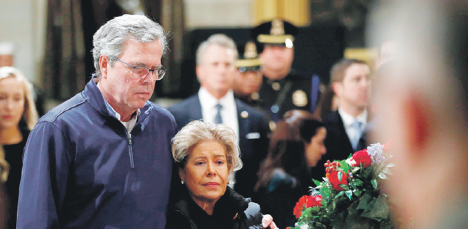 Obituario. El exgobernador de Florida Jeb Bush y su esposa Columba Bush rinden homenaje ante el ataúd con los restos de su padre ayer en el Capitolio.