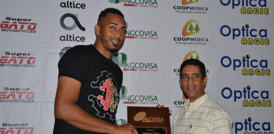 Amable Guzmán entrega una placa de reconocimiento a Michael Inoa, que le acredita como el Águila de la Semana.