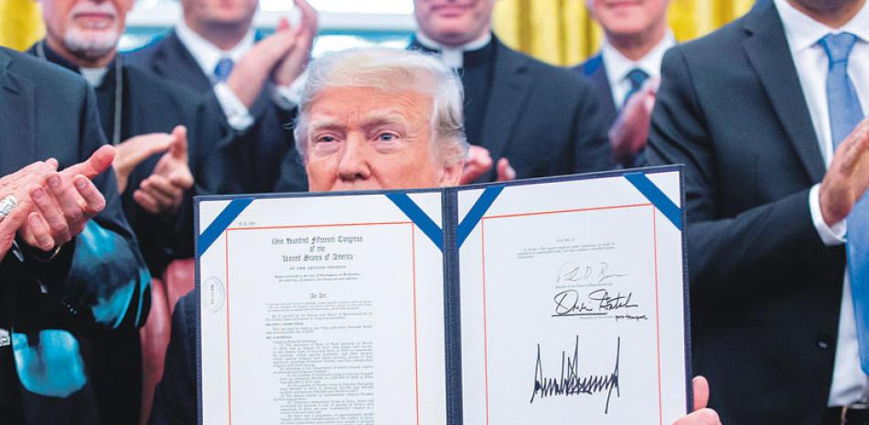 Firma. El presidente Donald J. Trump muestra un documento durante la firma del HR 390, la “Ley de alivio y rendición de cuentas del genocidio de Irak y Siria de 2018”, en la Oficina Oval de la Casa Blanca en Washington.