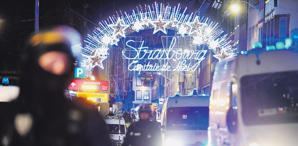 Ataque. Oficiales de policía hacen guardia cerca a donde podría ubicarse al atacante tras un tiroteo mortal ayer, en el Mercado de Navidad de Estrasburgo.