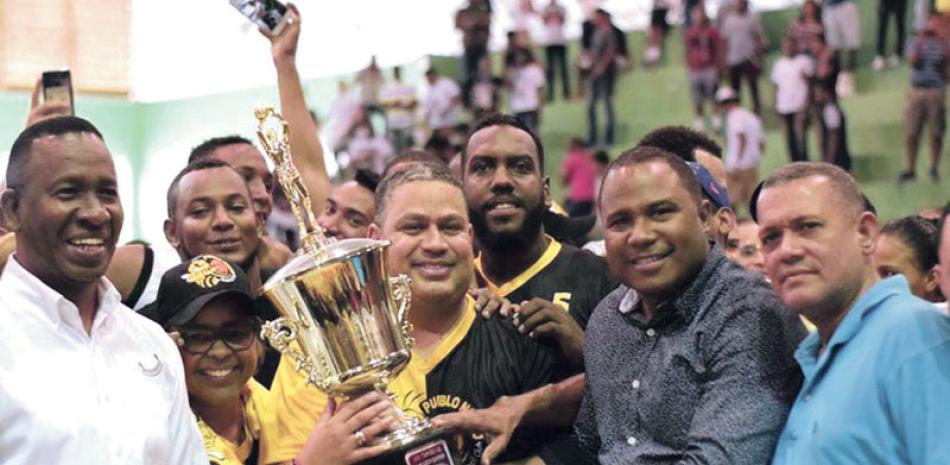 Radhamés Mateo entrega la copa de campeones a Omar Galán, presidente del club Pueblo Nuevo. Figura Fausto Araujo y otros dirigentes locales.