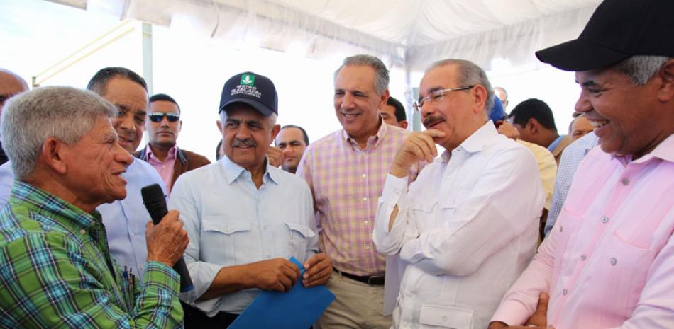 Beneficiarios. El presidente Danilo Medina escucha a uno de los productores de café de Baní, junto a los ministros de Agricultura y Administrativo de la Presidencia, Osmar Benítez y José Ramón Peralta.