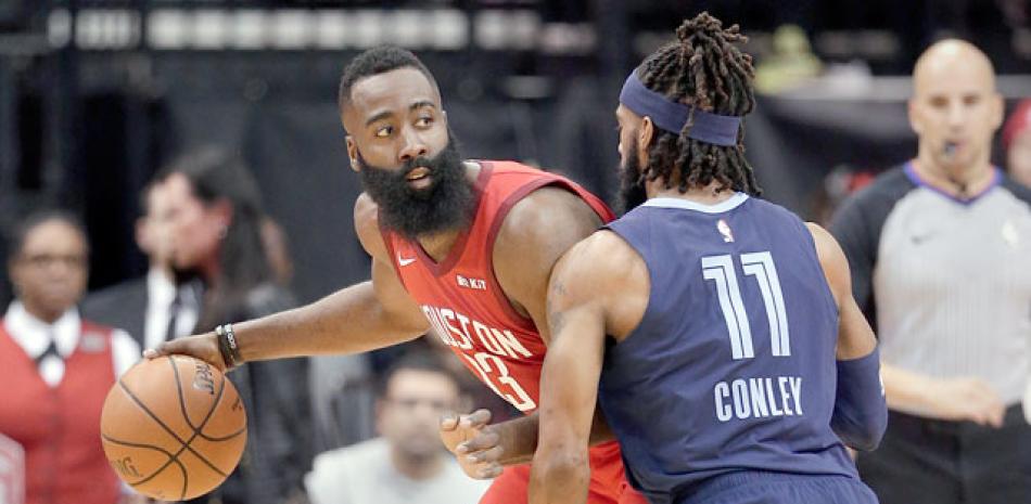 James Harden, de los Rockets, maneja el balón ante la cerrada defensa de Mike Conley, de los Grizzlies, en acción del partido del lunes en el baloncesto de la NBA.