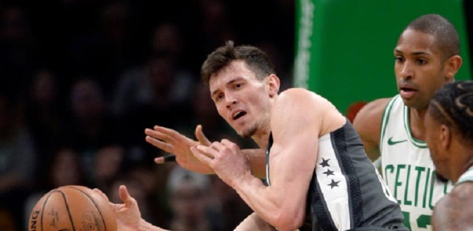 Rodions Kurucs, de los Nets, pasa la pelota ante la defensa de Al Horford y Marcus Smart, de los Celtics, durante la primera mitad del partido del lunes por la noche.