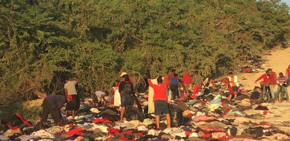 Camionetas. Detrás de la ropa usada lanzada en La Mina de Cambelén, en San Cristóbal, llegan cientos de personas en todo tipo de vehículos, los que salen cargados de mantas, cortinas, sábanas y guayaberas.