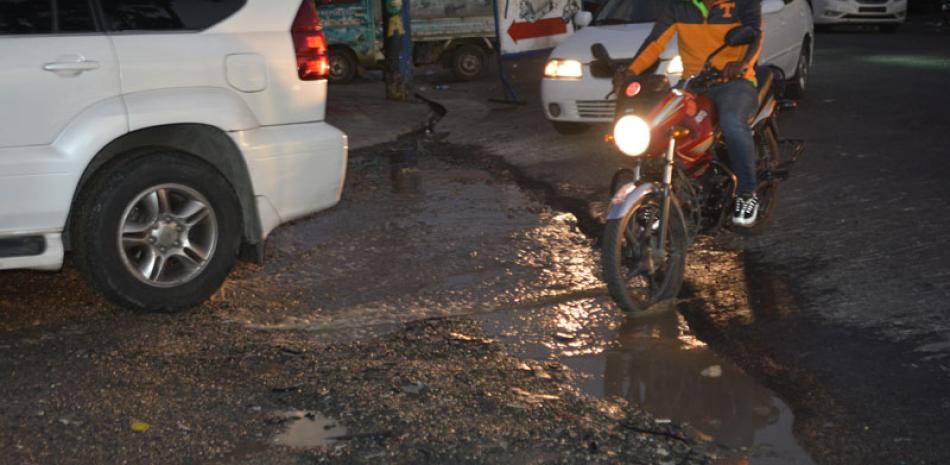Preocupación. El agujero está ubicado en la intersección de las calles Moca y Marcos Ruiz, en el sector Villa Juana, y pese a las denuncias de los choferes, las autoridades no han reconstruido el pavimento.