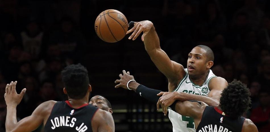 Al Horford, de los Celtics, intenta pasar la pelota ante la defensa de Josh Richardson y Derrick Jones Jr., de los Heat, en acción del partido de la NBA del lunes por la noche.