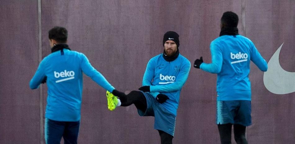 Lionel Messi, de frente, del Barcelona, realiza ejercicios junto a un par de compañeros previo al partido del miércoles en la ida de la semifinal de la Copa del Rey contra Real Madrid.