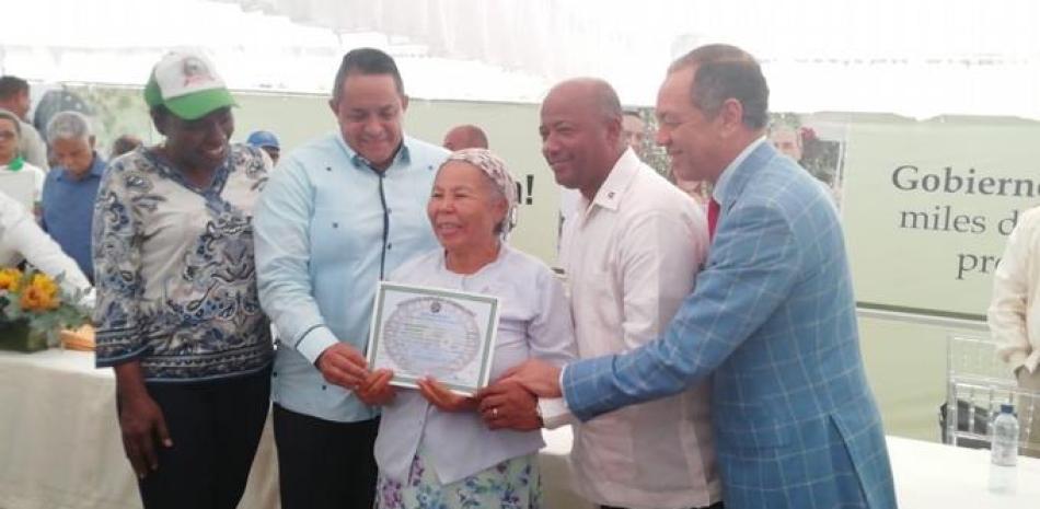 Felicia Confesor Hidalgo recibe su titulo de manos Emilio Toribio Olivo director del Instiruto Agrario y el senador Rubén Dario Cruz