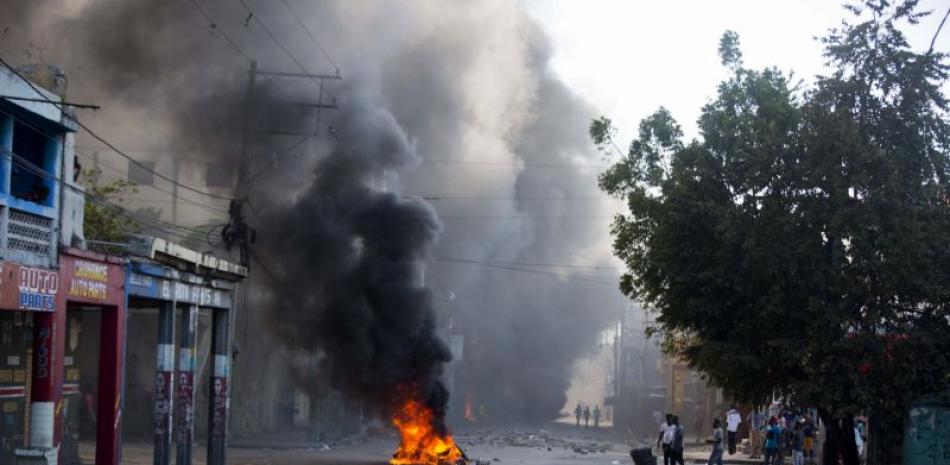 Neumáticos arden en una calle en Puerto Príncipe, Haití, durante una protesta para exigir la renuncia de presidente Jovenel Moise y que se les explique cómo el actual gobierno y gobiernos pasados han gastado los recursos de Petro Caribe.