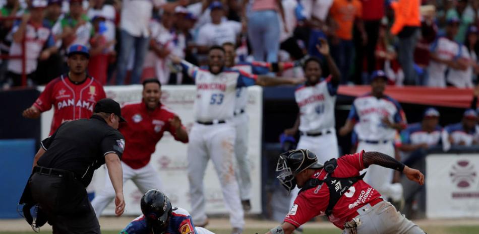 Emilio Gustave (c) de República Dominicana se arrastra al plato junto al receptor Rodrigo Vigil (d) durante un partido de la Serie del Caribe entre Toros de Herrera y Estrellas Orientales en el Estadio Nacional Rod Carew, en Ciudad de Panamá.