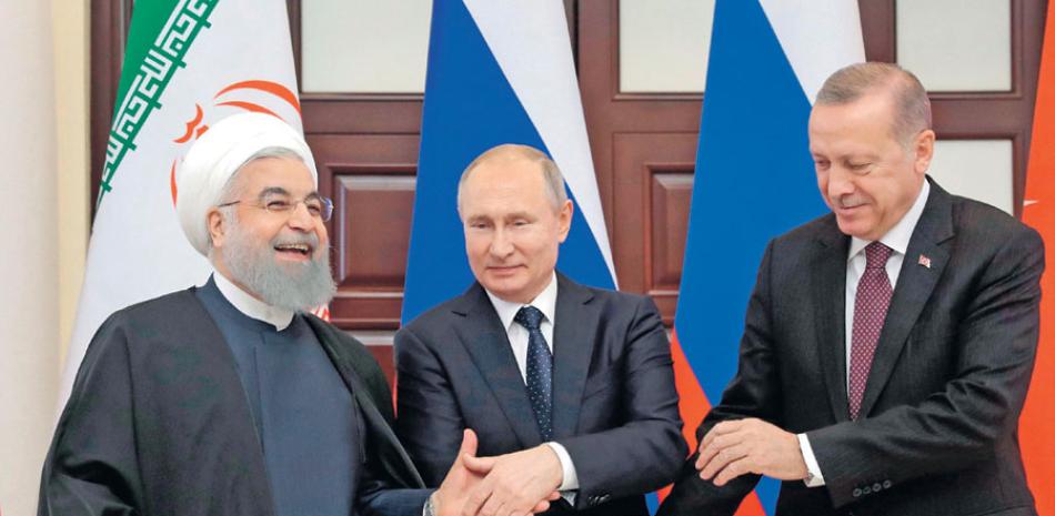 Reunión. El presidente iraní, Hasán Rohuani; su homólogo ruso, Vladímir Putin, y el turco, Recep Tayyip Erdogan, se estrechan la mano durante su reunión este jueves en el balneario de Sochi.