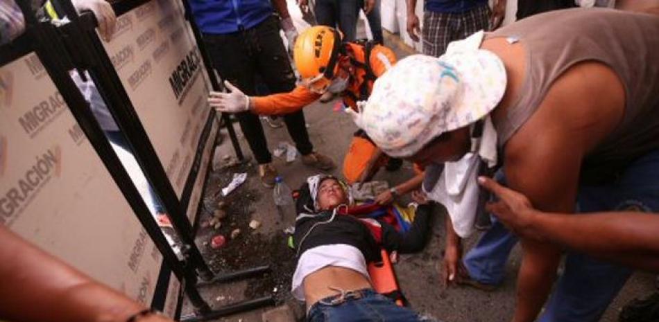 Un joven es atendido por personal médico durante los enfrentamientos entre manifestantes y miembros de la Policía Nacional Bolivariana.