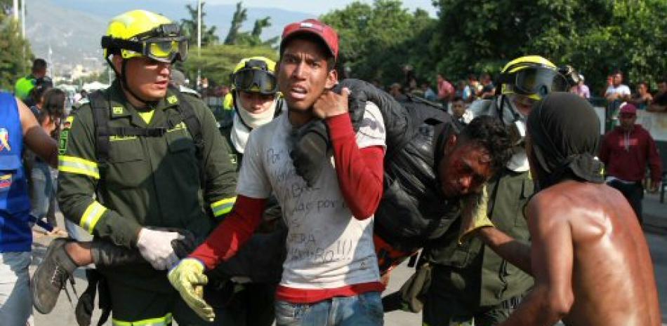 Un herido es socorrido durante los enfrentamientos con la Guardia Nacional Bolivariana. Foto AP