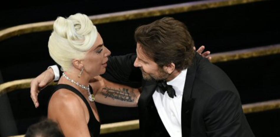 Bradley Cooper, a la derecha, felicita a Lady Gaga en la audiencia luego de ser anunciada ganadora de la mejor canción original para "Shallow" de "A Star Is Born" en los Oscar.