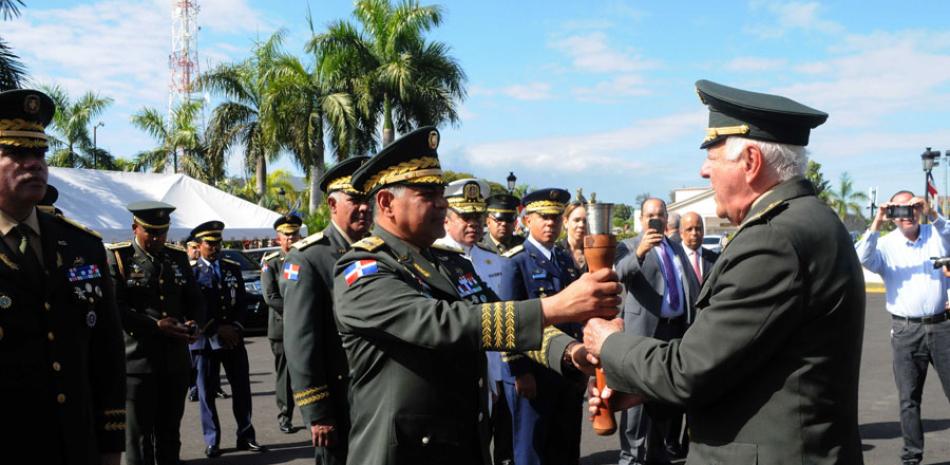 El ministro de Defensa, teniente general Rubén Darío Paulino Sem, recibe la antorcha de manos de Kalil Haché, presidente del Círculo Deportivo Militar.