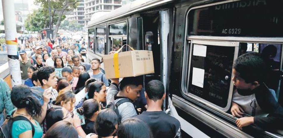 Apagón. Venezolanos tratan de abordar un autobús luego de un apagón que afectó varios estados y que duró mucho tiempo, afectando el transporte público.